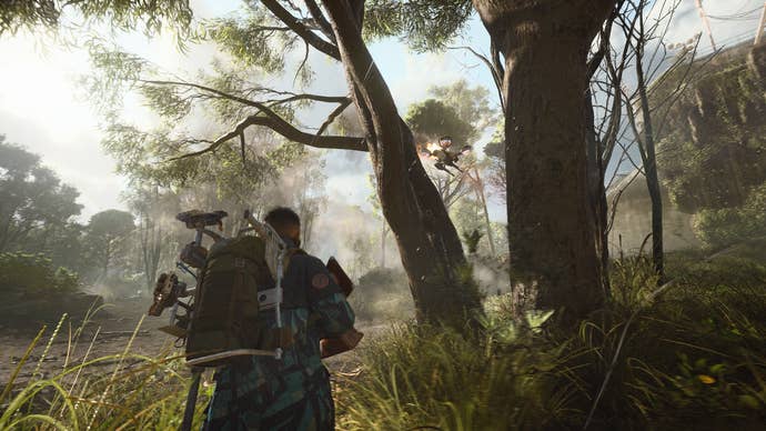 An ARC Raiders screenshot showing an armed character walking through a verdant forest as a drone approaches overhead.