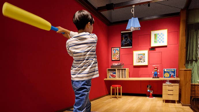 nintendo-museum-bats-resize A Nintendo Museum guest swinging a foam bat in a recreation of a Japanese home as an Ultra Machine DX pitching machine fires out balls.